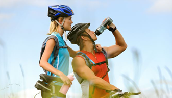 Two cyclists. One drinking from a water bottle
