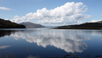 A body of water with hills in the background
